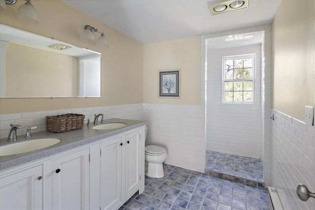 8 School House Vlg, Oak Bluffs, MA 02557 - bathroom with tile walls, toilet, double vanity, wainscoting, and walk in shower