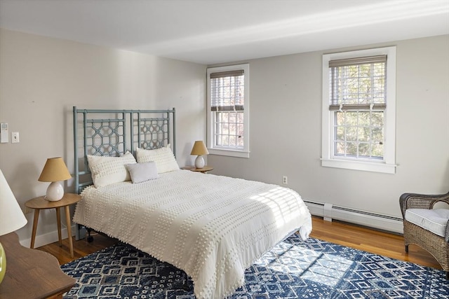 8 School House Vlg, Oak Bluffs, MA 02557 - bedroom featuring a baseboard radiator, wood finished floors, and multiple windows