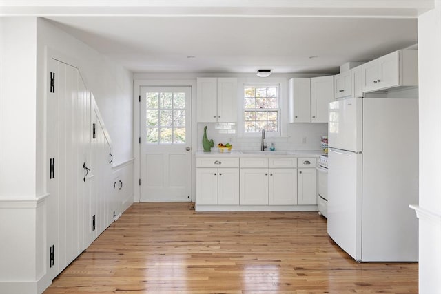 8 School House Vlg, Oak Bluffs, MA 02557 - kitchen with white appliances, a sink, light wood-style flooring, and white cabinetry