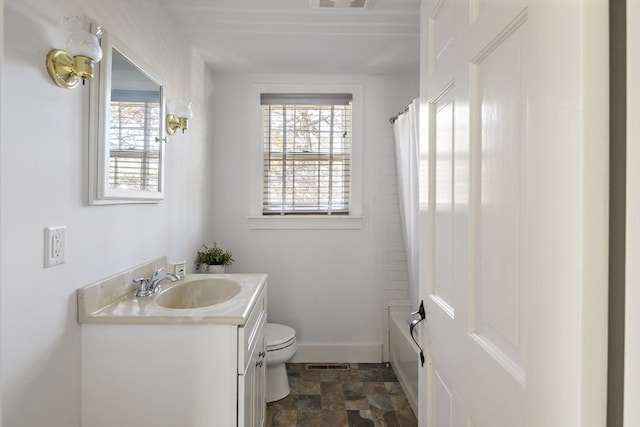 8 School House Vlg, Oak Bluffs, MA 02557 - bathroom featuring vanity, healthy amount of natural light, toilet, and stone finish floors