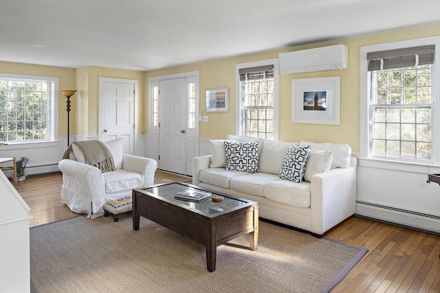 8 School House Vlg, Oak Bluffs, MA 02557 - living area with a wall unit AC, wood-type flooring, and a baseboard heating unit