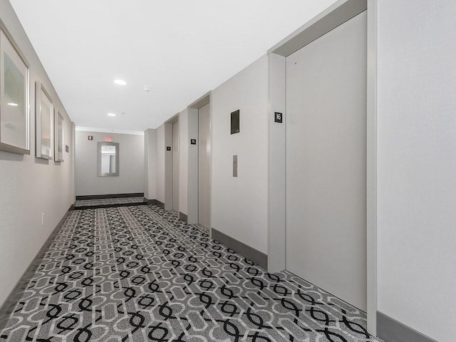 hallway featuring recessed lighting, elevator, and baseboards