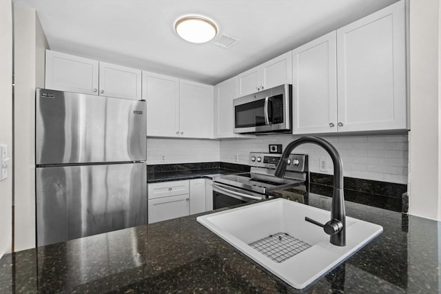 kitchen featuring visible vents, white cabinets, tasteful backsplash, a sink, and stainless steel appliances