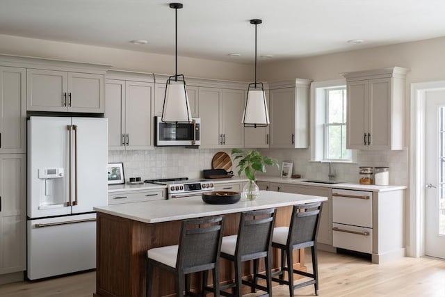 91 Miter Dr Unit 2-2, Plymouth, MA 02360 - kitchen with light countertops, light wood-style floors, a breakfast bar, and white appliances