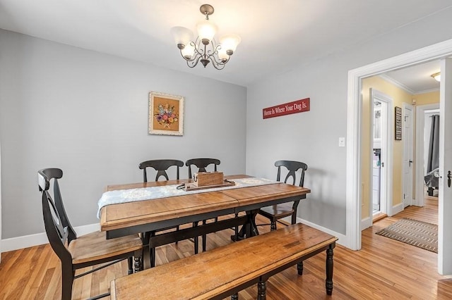 dining space with light wood-type flooring and an inviting chandelier