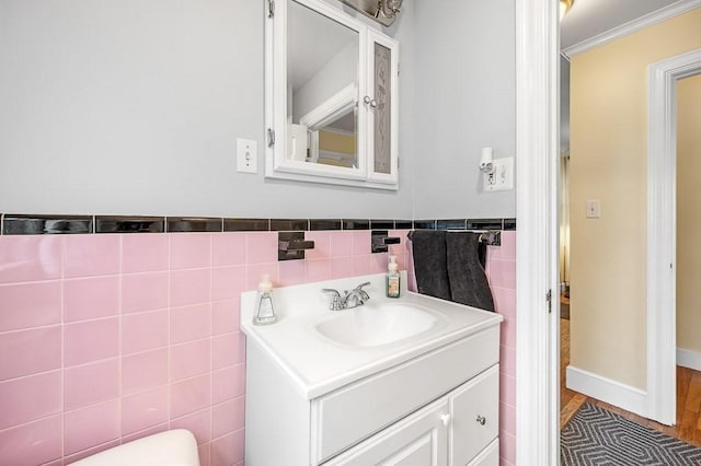 bathroom with ornamental molding, tile walls, and vanity