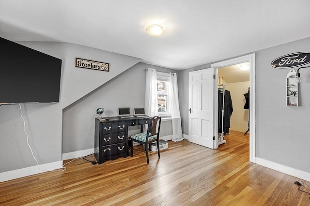 office area with vaulted ceiling and light hardwood / wood-style flooring