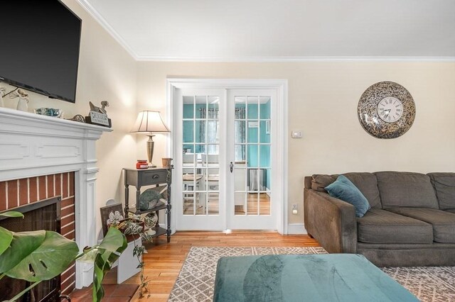 living room with hardwood / wood-style floors, crown molding, and a fireplace