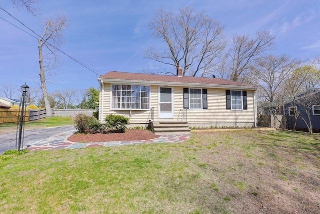 view of front of property featuring fence, a chimney, and a front yard