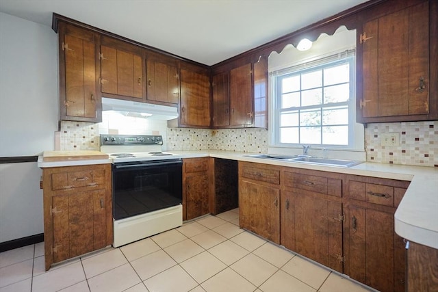 kitchen featuring a sink, light countertops, decorative backsplash, under cabinet range hood, and white electric range