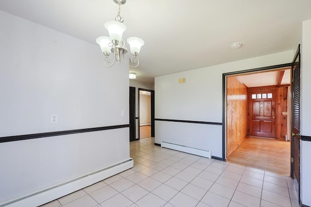 spare room featuring light tile patterned floors, baseboards, a baseboard radiator, a baseboard heating unit, and an inviting chandelier