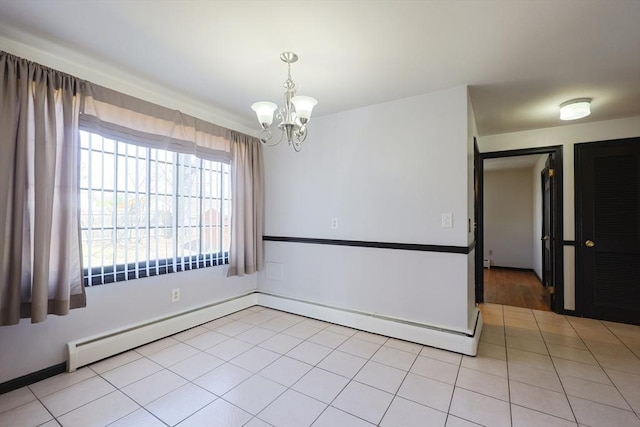 spare room with light tile patterned flooring, baseboards, an inviting chandelier, and a baseboard radiator