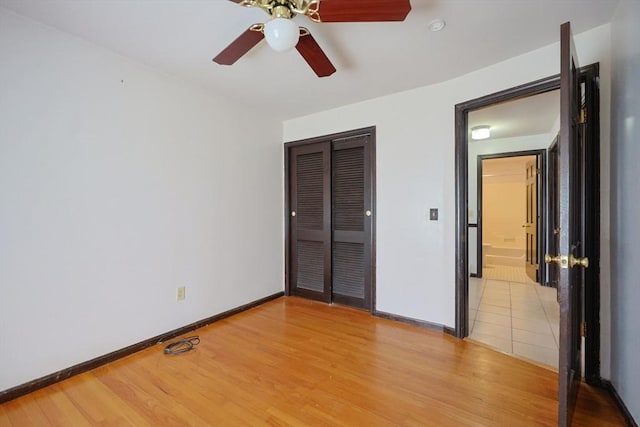 unfurnished bedroom with light wood-style floors, baseboards, a ceiling fan, and a closet