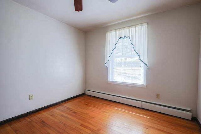 unfurnished room featuring a ceiling fan, baseboards, baseboard heating, and light wood-style floors