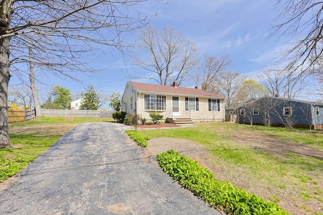 bungalow-style house with fence, driveway, and a front yard