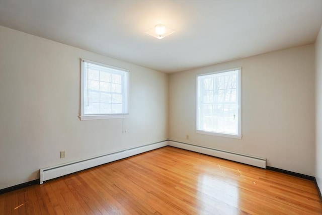unfurnished room with baseboards, wood finished floors, and a healthy amount of sunlight