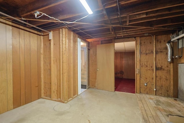 unfinished basement featuring wooden walls