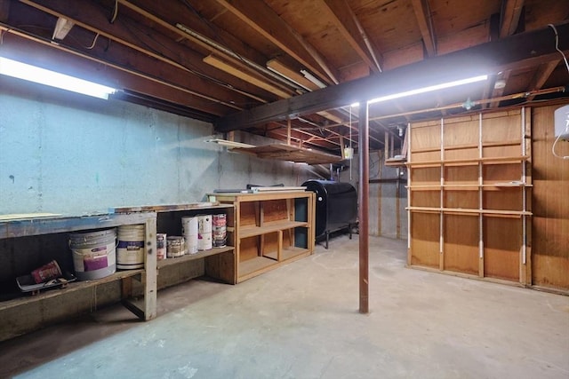 unfinished below grade area featuring a workshop area and heating fuel
