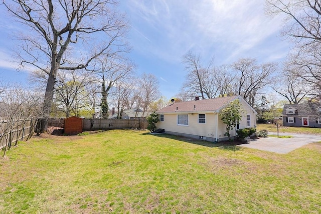 view of yard featuring a patio, a fenced backyard, an outbuilding, and a storage shed