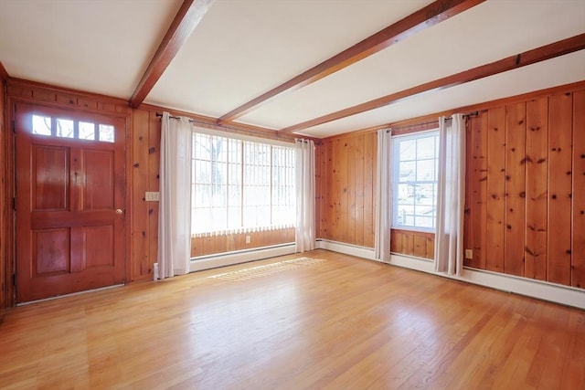 foyer with wood walls, beam ceiling, light wood-style floors, baseboards, and a baseboard heating unit