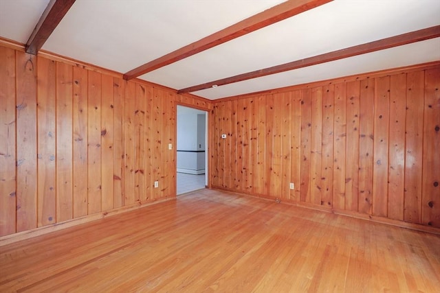empty room featuring wood walls, beam ceiling, and wood finished floors