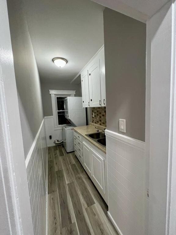 interior space with light hardwood / wood-style floors, sink, white cabinets, and washer / clothes dryer