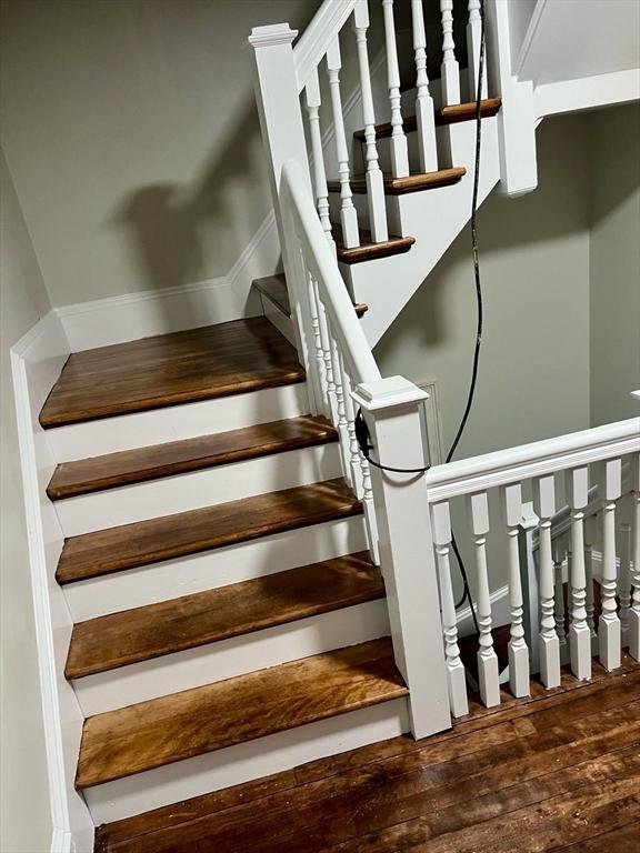 stairway with hardwood / wood-style floors