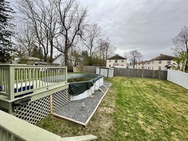 view of yard featuring a pool side deck and a storage unit