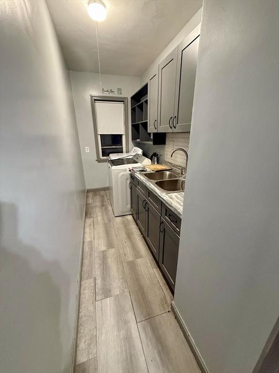 kitchen featuring sink, gray cabinetry, and light wood-type flooring