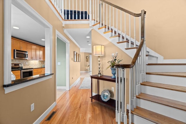 staircase with recessed lighting, visible vents, baseboards, and wood finished floors