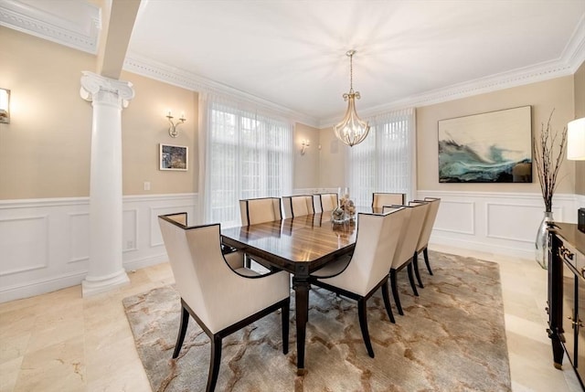 43 Bristol Rd, Wellesley, MA 02481 - dining area featuring ornate columns, a decorative wall, crown molding, a wainscoted wall, and a chandelier