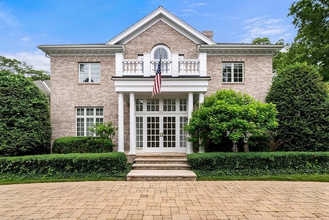 43 Bristol Rd, Wellesley, MA 02481 - view of front of home featuring french doors, a balcony, brick siding, and a chimney