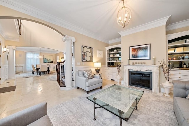 43 Bristol Rd, Wellesley, MA 02481 - living area featuring decorative columns, ornamental molding, arched walkways, a fireplace, and a chandelier