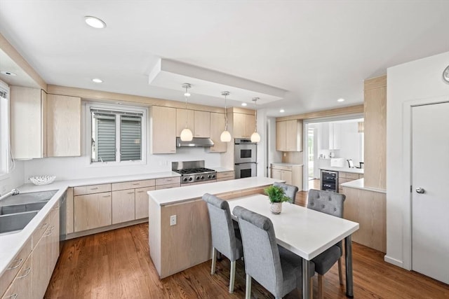 124 William St, Dartmouth, MA 02748 - kitchen featuring appliances with stainless steel finishes, light brown cabinets, a sink, a kitchen island, and under cabinet range hood