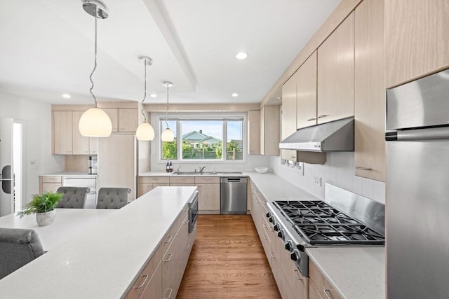 124 William St, Dartmouth, MA 02748 - kitchen with under cabinet range hood, stainless steel appliances, a sink, light countertops, and recessed lighting
