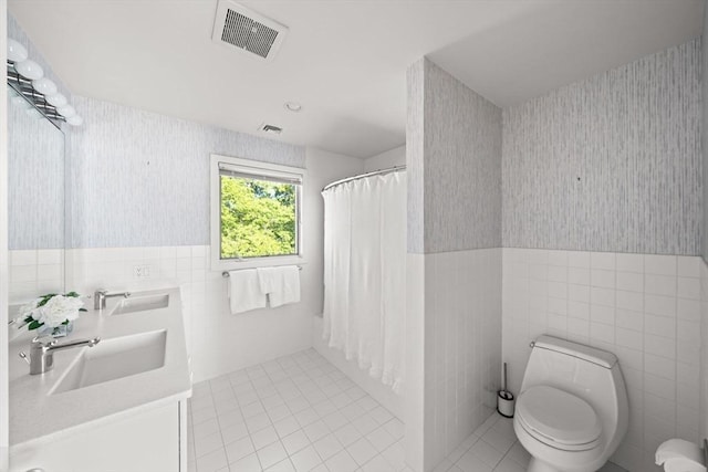 124 William St, Dartmouth, MA 02748 - bathroom featuring wallpapered walls, tile walls, tile patterned floors, wainscoting, and toilet