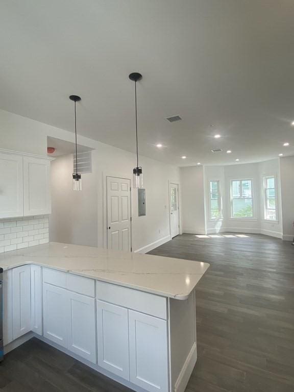 kitchen with white cabinets, decorative light fixtures, and dark wood-type flooring