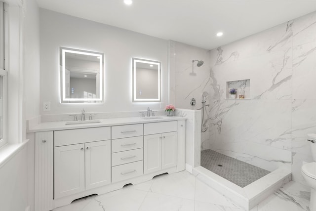 bathroom with vanity, toilet, and a tile shower