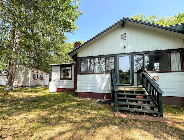 5 Maguire Rd, Ashburnham, MA 01430 - back of property featuring a chimney, entry steps, and a lawn