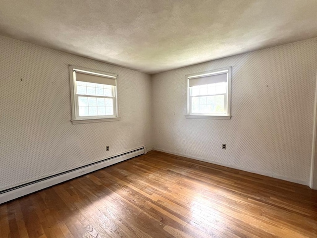 31 Dix Rd, Woburn, MA 01801 - spare room with a baseboard radiator, wood-type flooring, and plenty of natural light