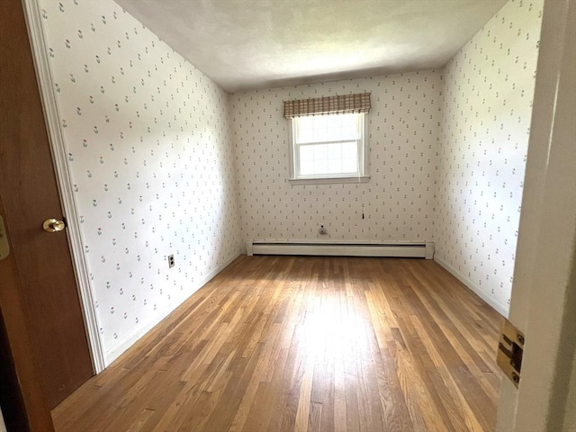 31 Dix Rd, Woburn, MA 01801 - unfurnished room featuring wallpapered walls, a baseboard heating unit, and light wood-type flooring