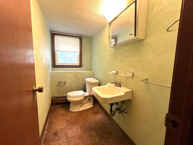 31 Dix Rd, Woburn, MA 01801 - half bath featuring a baseboard heating unit, a textured ceiling, a textured wall, and tile patterned floors