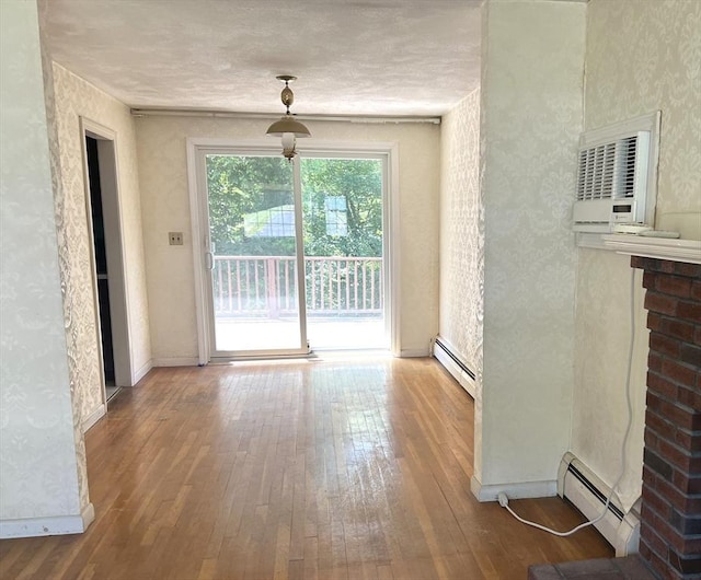 31 Dix Rd, Woburn, MA 01801 - unfurnished dining area with a baseboard radiator, wood-type flooring, a wall mounted AC, and wallpapered walls