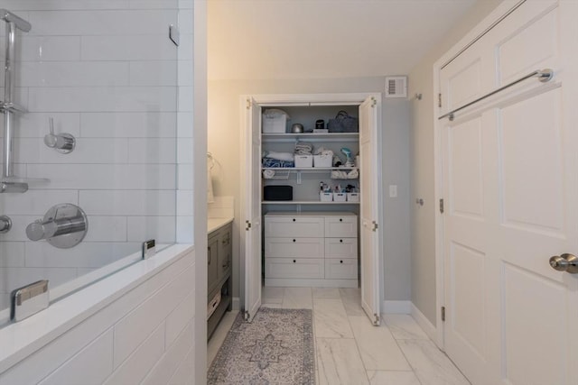 73 Harold St, Milton, MA 02186 - full bathroom with tiled shower, marble look tile flooring, baseboards, and a walk in closet