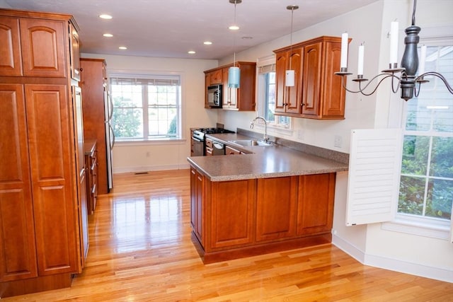 31 Mulligan Dr Unit 31, Weymouth, MA 02190 - kitchen with light wood-style flooring, brown cabinets, appliances with stainless steel finishes, a peninsula, and recessed lighting