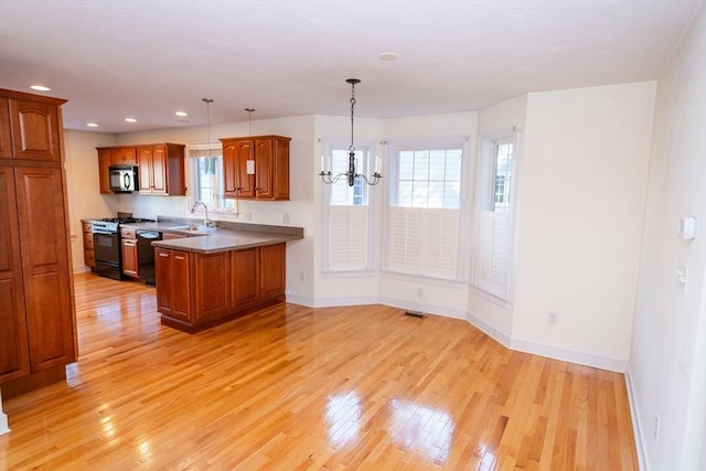 31 Mulligan Dr Unit 31, Weymouth, MA 02190 - kitchen featuring black appliances, brown cabinetry, light wood-type flooring, pendant lighting, and a chandelier