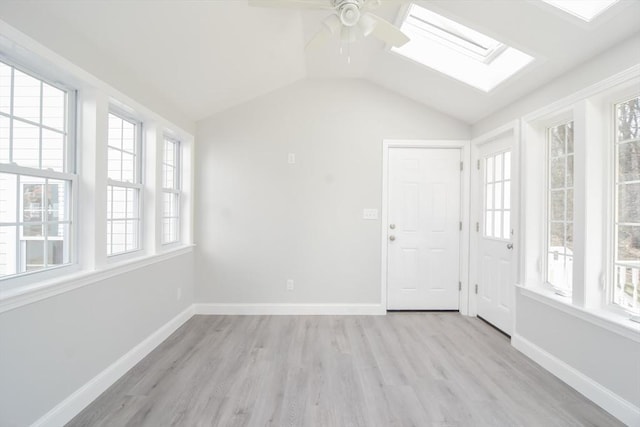 interior space with vaulted ceiling with skylight and ceiling fan