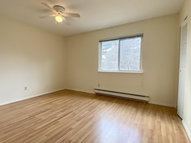 unfurnished room featuring a baseboard heating unit, ceiling fan, light wood finished floors, and baseboards