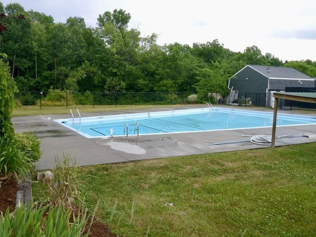 view of pool featuring a yard and fence