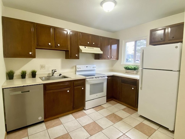 kitchen with light countertops, white appliances, a sink, and under cabinet range hood